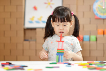 young girl play number sticks fine motor skill game for homeschooling