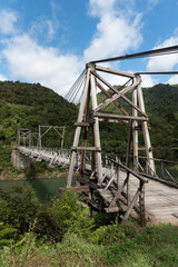 The historic Tauranga Bridge over the Waioeka River gorge. It is a wooden suspension bridge in the East Coast region, North Island, New Zealand.
