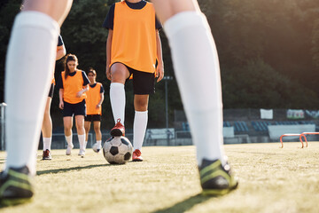 Unrecognizable female soccer player getting ready to kick the ball during practice on playing field.
