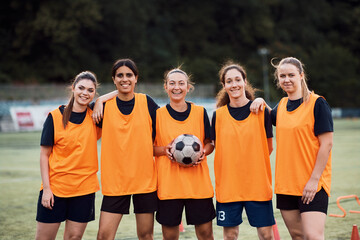 Portrait of happy women's soccer team at stadium looking at camera.