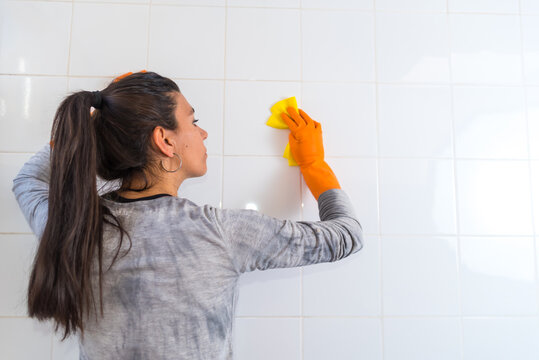 young latina woman, beautiful, cleaning the bathroom, wearing gloves