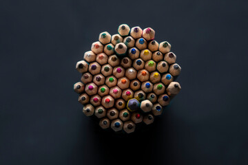 many colorful pencils in the shape of circle, pile of crayons view from above