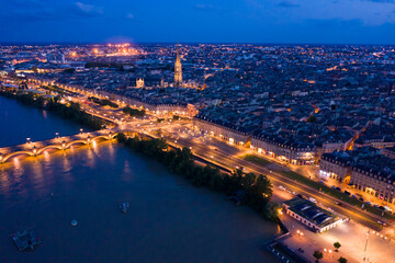 Fototapeta premium Panoramic aerial view of illuminated Bordeaux city on Garonne river at night