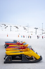 Sleds lined up against the backdrop of a ski slope. Winter holidays. Extreme sport. Vacation, travel content. 