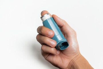 Holding an asthma inhaler on white background with copy space