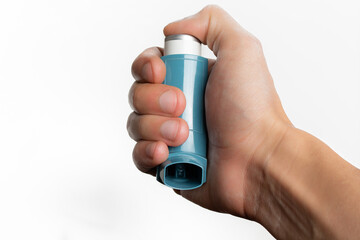 Hand holding an asthma inhaler on white background with copy space