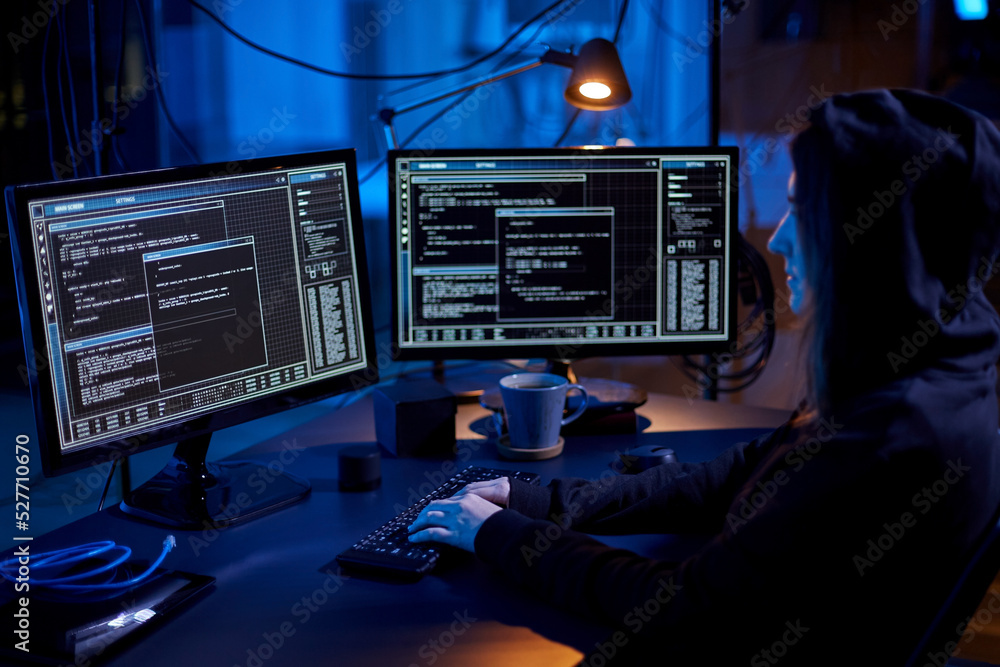 Poster cybercrime, hacking and technology concept - female hacker in dark room writing code or using comput