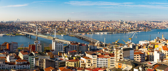 Fototapeta na wymiar Panoramic view from Galata Tower of Golden Horn bay with cable-stayed metro bridge and highway Ataturk Bridge connecting Beyoglu and Fatih districts in Istanbul, Turkey..