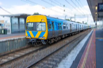 Obraz premium Commuter train approaching a train station in Melbourne Victoria Australia