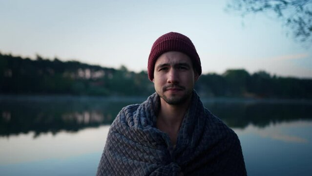 Bearded man wrapping at the towel feeling cold and chills after the winter swimming