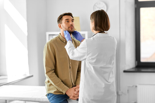 medicine, healthcare and people concept - female doctor checking lymph nodes of man patient at hospital
