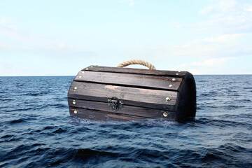 Closed wooden treasure chest floating in sea