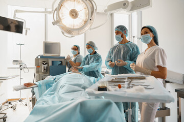 Concentrated professional surgical team working with a patient in an operation room