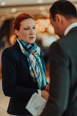Photo of a businessman and businesswoman discussing business projects in a modern corporation. Selective focus 