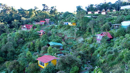 Colorful cabins in a garden on the side of the mountain at the high altitude Paraiso Quetzal Lodge...