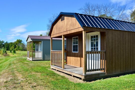 American style wooded shed, with porch. A shed is typically simple, single-story roofed structure in a back garden or on an allotment that is used for storage, hobbies, or as a workshop. Exterior view