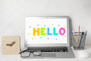 Modern laptop with word HELLO on screen at workplace © Pixel-Shot