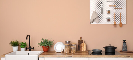 Interior of stylish kitchen with white furniture, utensils and pegboard
