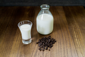 ミルクとコーヒー豆、木目の背景