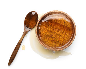 Wooden bowl and spoon with tasty maple syrup on white background