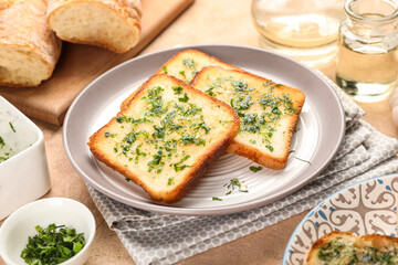 Plate with slices of delicious toasted garlic bread on table, closeup