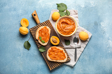 Composition with delicious sandwiches and apricot jam on color background