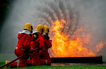 Close up firefighter team with three man support together to distinguish fire using water curtain...