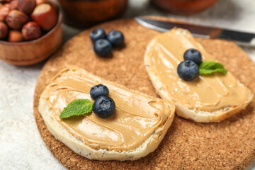 Cork mat of tasty sandwiches with nut butter on table, closeup