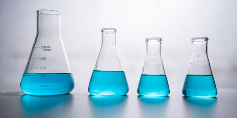 chemical science laboratory with blue liquid in test tube beaker and glassware equipment, research term of biology or chemistry and medicine biotechnology experiment working on scientific glass