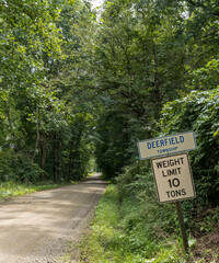 Road signs on the side of a dirt road in the woods in Deerfield Township, Pennsylvania, USA on a sunny summer day