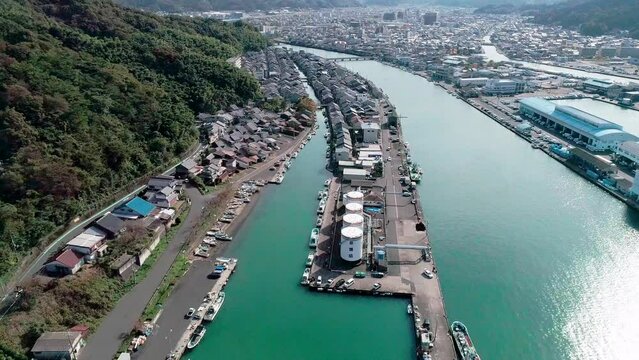 ドローンで空撮された、京都府舞鶴市の「吉原入江」の風景。水路に並ぶ漁船と民家、背景の山々までを見渡せる、ノスタルジックな漁師町の全景。観光PR、地域紹介、日本の港町の魅力を伝える広告・映像素材に。 | Aerial view of Yoshiwara Inlet in Maizuru, Kyoto.