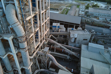 Cement plant with high factory structure and tower cranes at industrial production area....