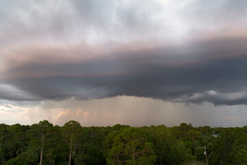 Obraz premium Dark stormy clouds forming on gloomy sky before heavy rainfall over suburban town area