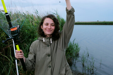 curly young girl on a fishing trip catches fish