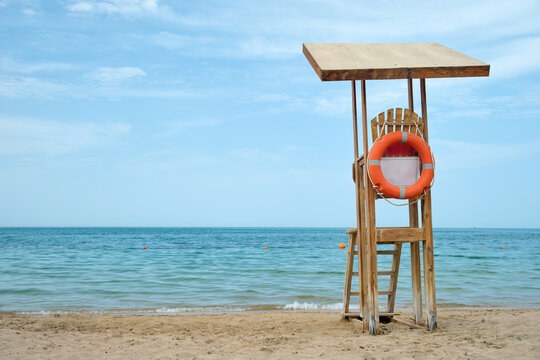 Emplty wooden lifeguard station on sandy beach on ocean shore in summer - Powered by Adobe