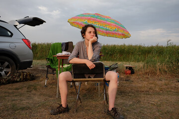 curly young girl on a fishing trip catches fish