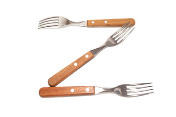 3 forks with wooden handles making the letter Z on a white background