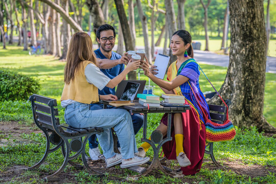 group of diverse asian university LGBTQ student classmate as teamwork doing group homework together in campus park