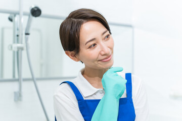 Fototapeta premium エプロンと手袋をつけ考える日本人女性