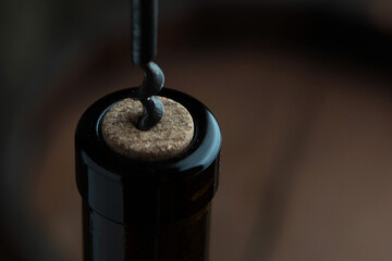 A bottle of wine opens with corkscrew. Close up. A corkscrew with a wooden handle. Out of...