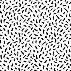 Seamless pattern with small brush strokes and dashes. Hand drawn charcoal or pencil strokes. Expressive seamless abstract vector backgrounds in black and white. Simple childish scribble ornament. 