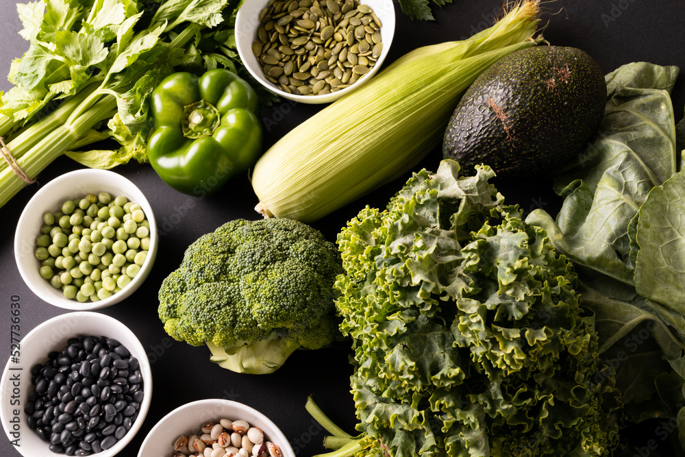 Wall mural Directly above shot of various green vegetables, fruit, herb with seeds and legumes on table