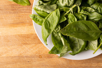 Directly above shot of fresh baby spinach in place on cutting board