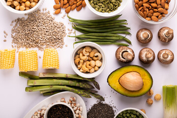 Overhead view of healthy food and ingredients arranged on white table, copy space