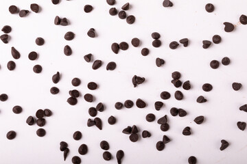 Full frame shot of fresh chocolate chips scattered over white background