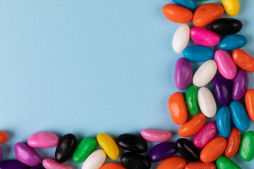 Overhead view of colorful candies and copy space on blue background
