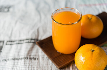 glass of fresh orange juice with fresh fruits on wooden table, high Vitamin C, orange drink