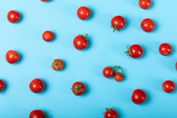 Obraz premium Directly above view of fresh red tomatoes scattered over blue background