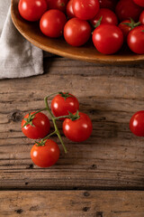 Directly above view of fresh red cherry tomatoes with plate and napkin on wooden table