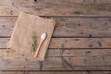 Foto op Canvas Directly above shot of rock salt in wooden spoon and rosemary on jute fabric at table © WavebreakMediaMicro